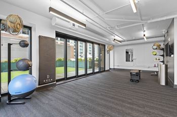 a workout room with a yoga ball and other exercise equipment in front of a window at Deca Apartments, Greenville, SC